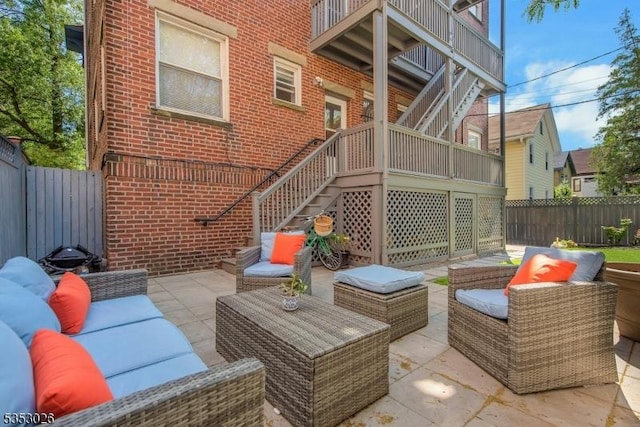 view of patio / terrace with an outdoor hangout area, a fenced backyard, and stairs