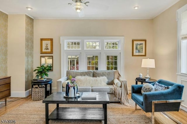 living area with ceiling fan, light wood-style flooring, and baseboards