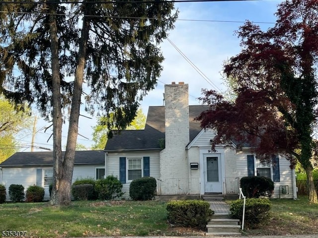view of front of home featuring a front lawn and a chimney