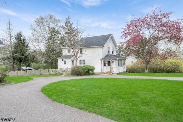 21 Vones Ln, Raritan Boro, NJ 08869 - view of side of property with a yard, curved driveway, fence, and a shingled roof