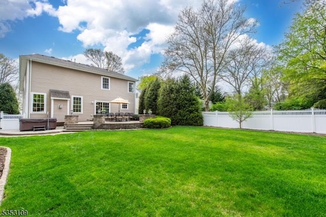 back of house with fence, a yard, a hot tub, and a patio area