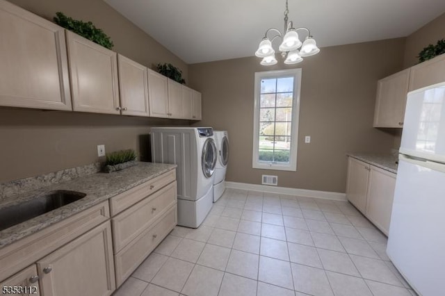 laundry area with visible vents, light tile patterned flooring, baseboards, washer and clothes dryer, and a chandelier