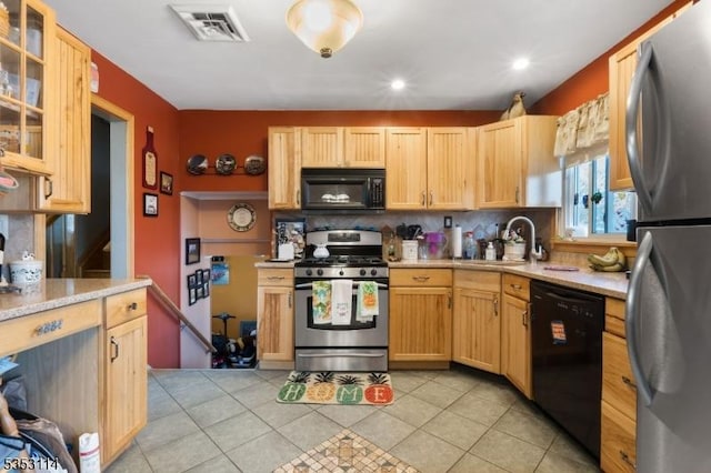 kitchen featuring a sink, light tile patterned floors, tasteful backsplash, black appliances, and visible vents