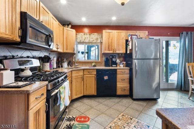 kitchen featuring a sink, light tile patterned flooring, tasteful backsplash, black appliances, and light countertops