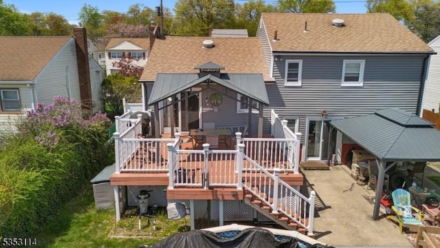 back of property with roof with shingles, stairway, a patio, and a wooden deck