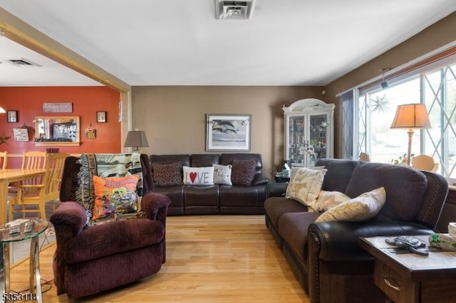 living room with visible vents and light wood-style flooring