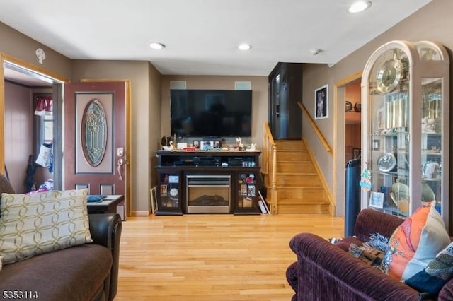living area with baseboards, stairway, wood finished floors, and recessed lighting