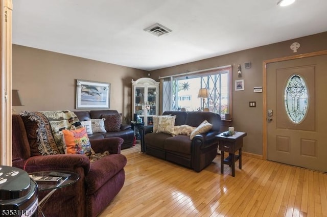 living area featuring visible vents, baseboards, and light wood-style floors