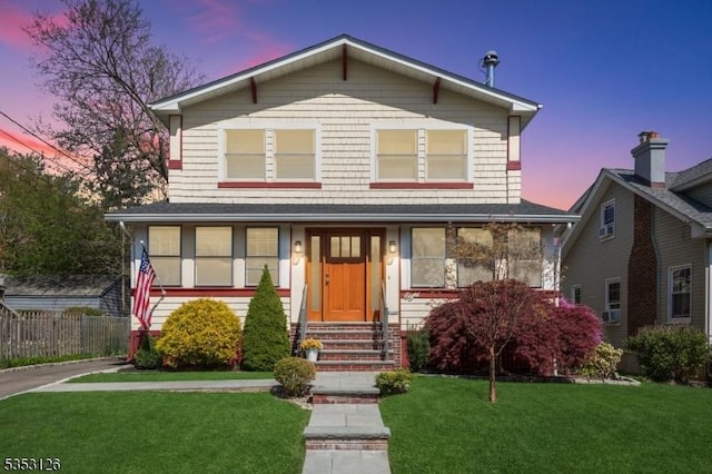 view of front of house with a lawn, fence, and entry steps