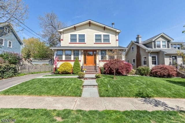 view of front facade featuring fence and a front yard