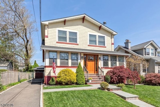 view of front of property featuring a detached garage, a front yard, fence, and entry steps