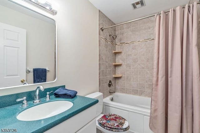 bathroom with vanity, toilet, visible vents, and shower / tub combo