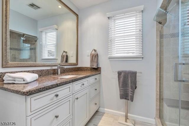 full bath with visible vents, a stall shower, and vanity