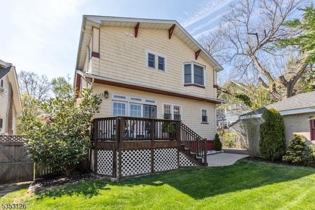 back of property with fence, a wooden deck, a yard, and stairway