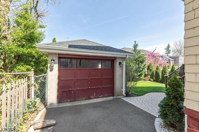 detached garage with fence and driveway