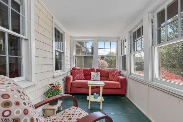 sunroom / solarium with ornamental molding and wood finished floors
