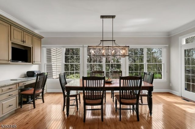 dining room with crown molding, visible vents, a healthy amount of sunlight, and light wood finished floors
