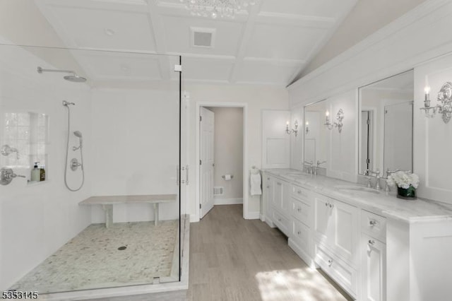 bathroom with wood finished floors, a stall shower, a chandelier, and vanity