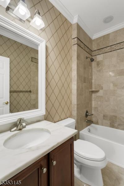 bathroom with crown molding, toilet, washtub / shower combination, and vanity