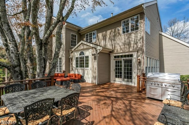 rear view of house with a wooden deck and outdoor dining area