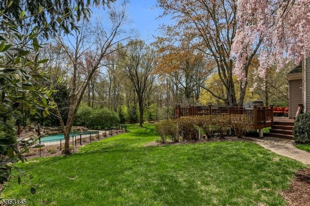 view of yard featuring fence, a fenced in pool, and a deck