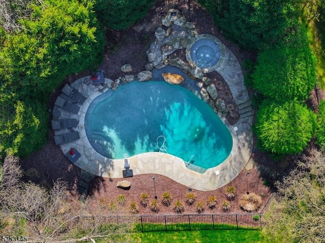 view of swimming pool featuring fence