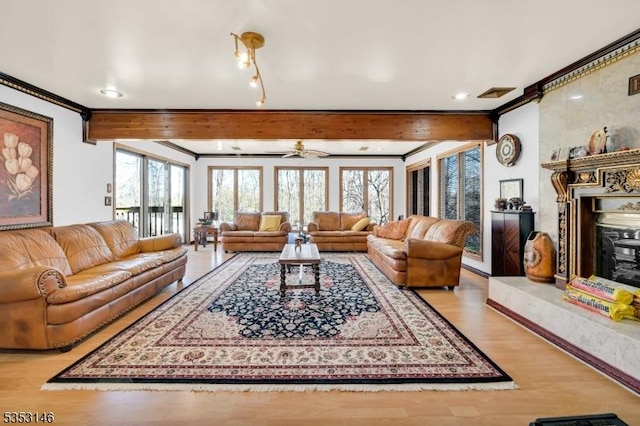 living area with crown molding, plenty of natural light, and wood finished floors