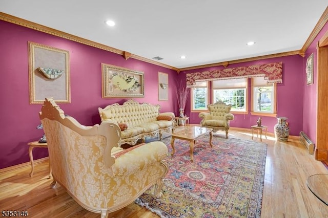 living room featuring baseboards, ornamental molding, a baseboard radiator, and recessed lighting