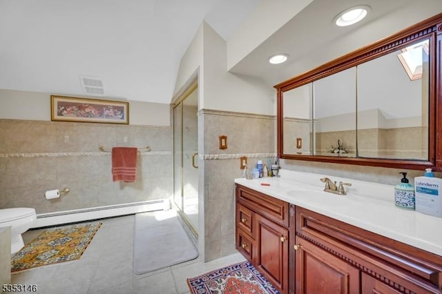 full bath featuring tile walls, baseboard heating, a stall shower, vanity, and toilet