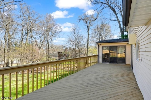wooden deck featuring a lawn