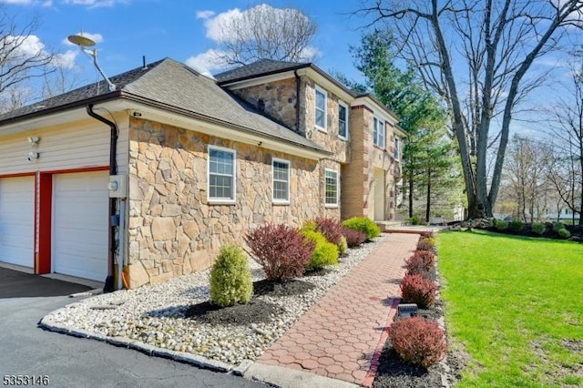 view of home's exterior with a lawn, roof with shingles, and stone siding
