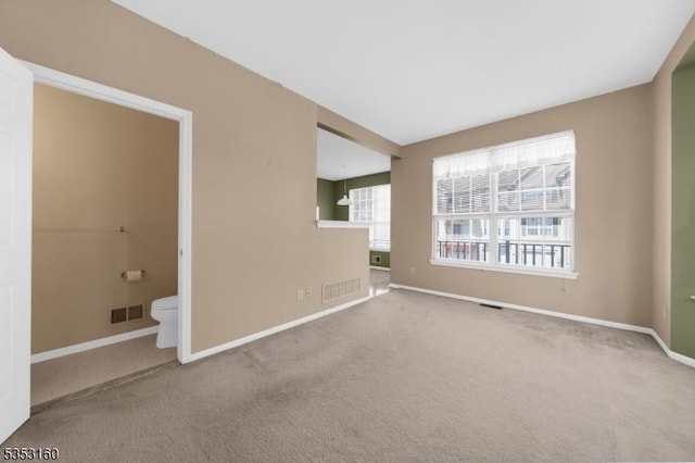 unfurnished room with visible vents, carpet, and baseboards