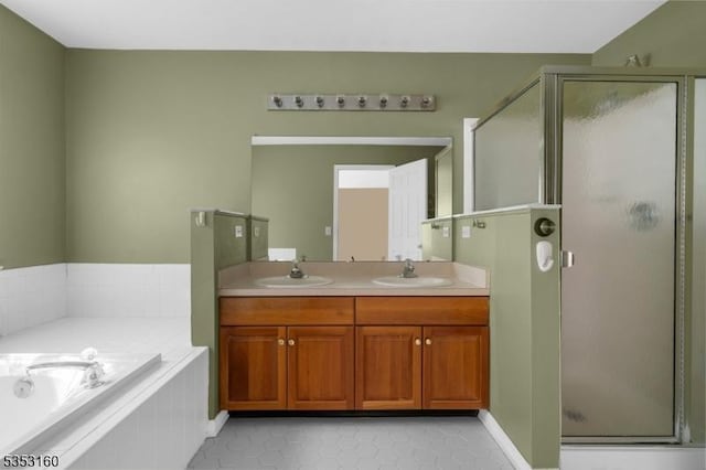 full bathroom featuring a garden tub, a sink, and a stall shower