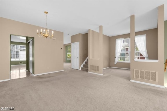 unfurnished living room featuring visible vents, carpet floors, and an inviting chandelier