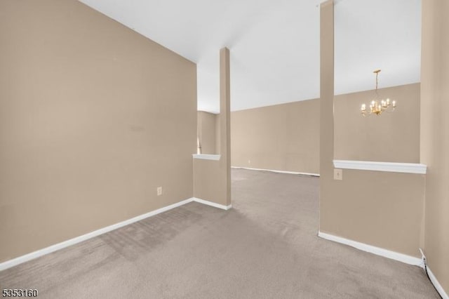 unfurnished room featuring carpet floors, baseboards, a chandelier, and vaulted ceiling