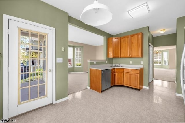 kitchen with stainless steel dishwasher, light countertops, baseboards, and plenty of natural light