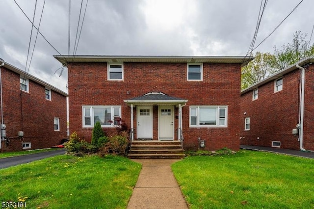 view of front facade with a front yard and brick siding