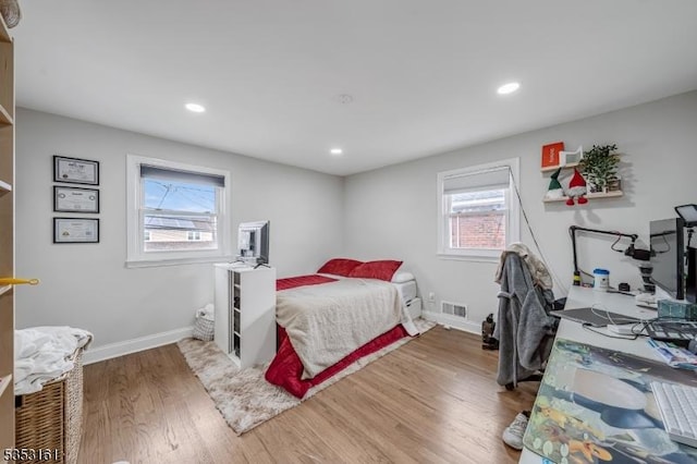 bedroom featuring baseboards, recessed lighting, wood finished floors, and visible vents