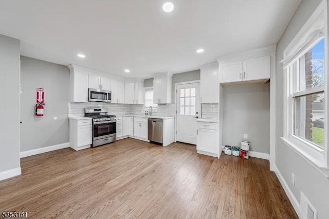 kitchen with visible vents, light countertops, white cabinets, tasteful backsplash, and stainless steel appliances