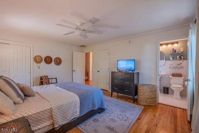 bedroom featuring a ceiling fan, crown molding, wood finished floors, a closet, and connected bathroom