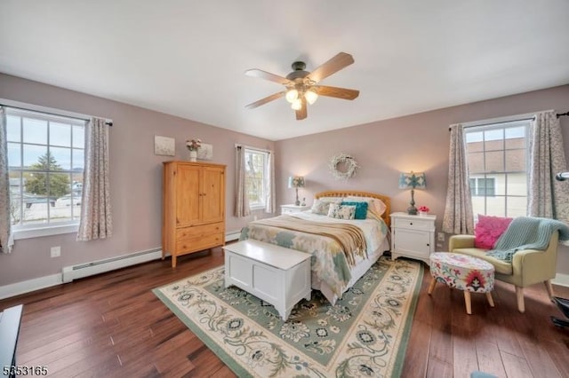 bedroom featuring baseboard heating, wood finished floors, and a ceiling fan