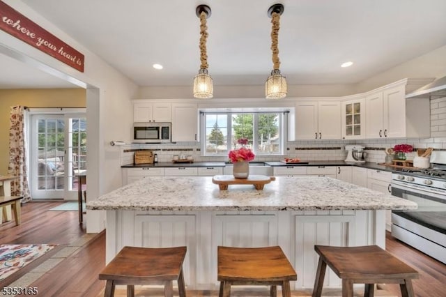 kitchen featuring white cabinets, stainless steel appliances, a wealth of natural light, and decorative backsplash