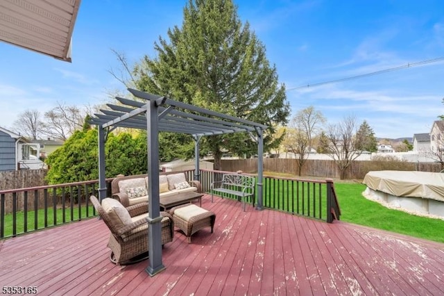 wooden terrace with outdoor lounge area, a fenced backyard, a yard, and a pergola