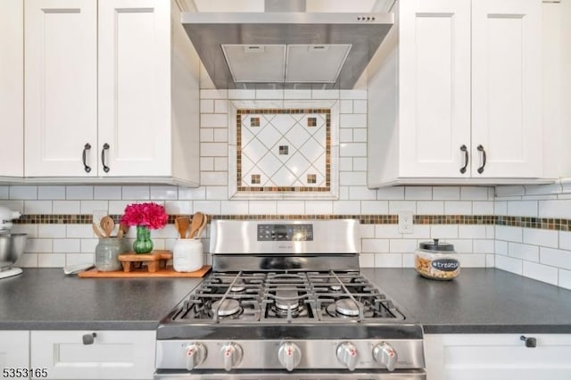 kitchen featuring dark countertops, extractor fan, white cabinets, and gas stove