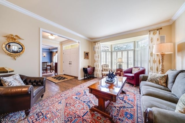 living area with crown molding, baseboards, and wood finished floors