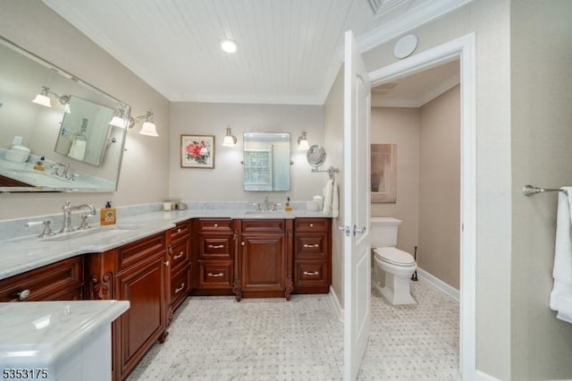 bathroom with double vanity, a sink, baseboards, and toilet