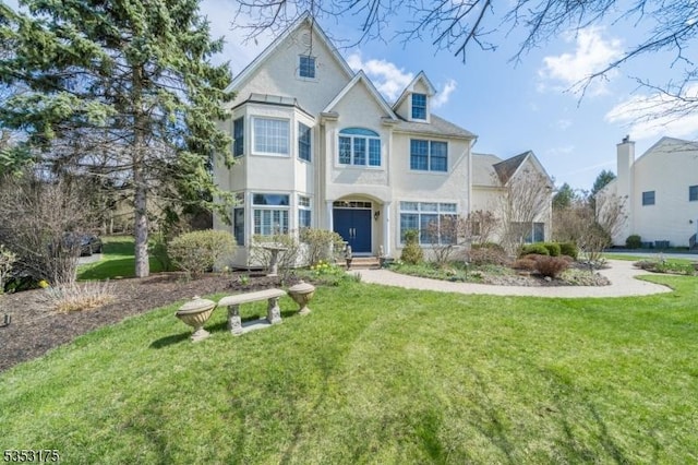 traditional-style house featuring a front yard and stucco siding