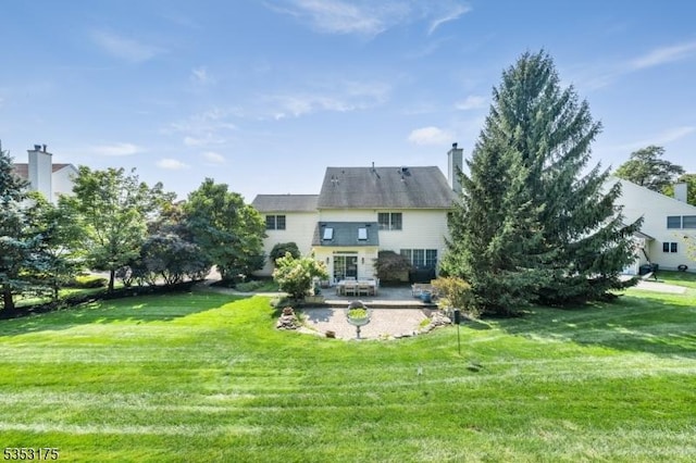 rear view of house featuring a patio and a lawn