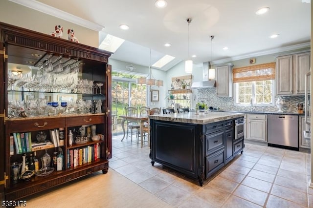 kitchen with appliances with stainless steel finishes, a healthy amount of sunlight, wall chimney range hood, and tasteful backsplash