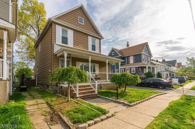 american foursquare style home featuring covered porch
